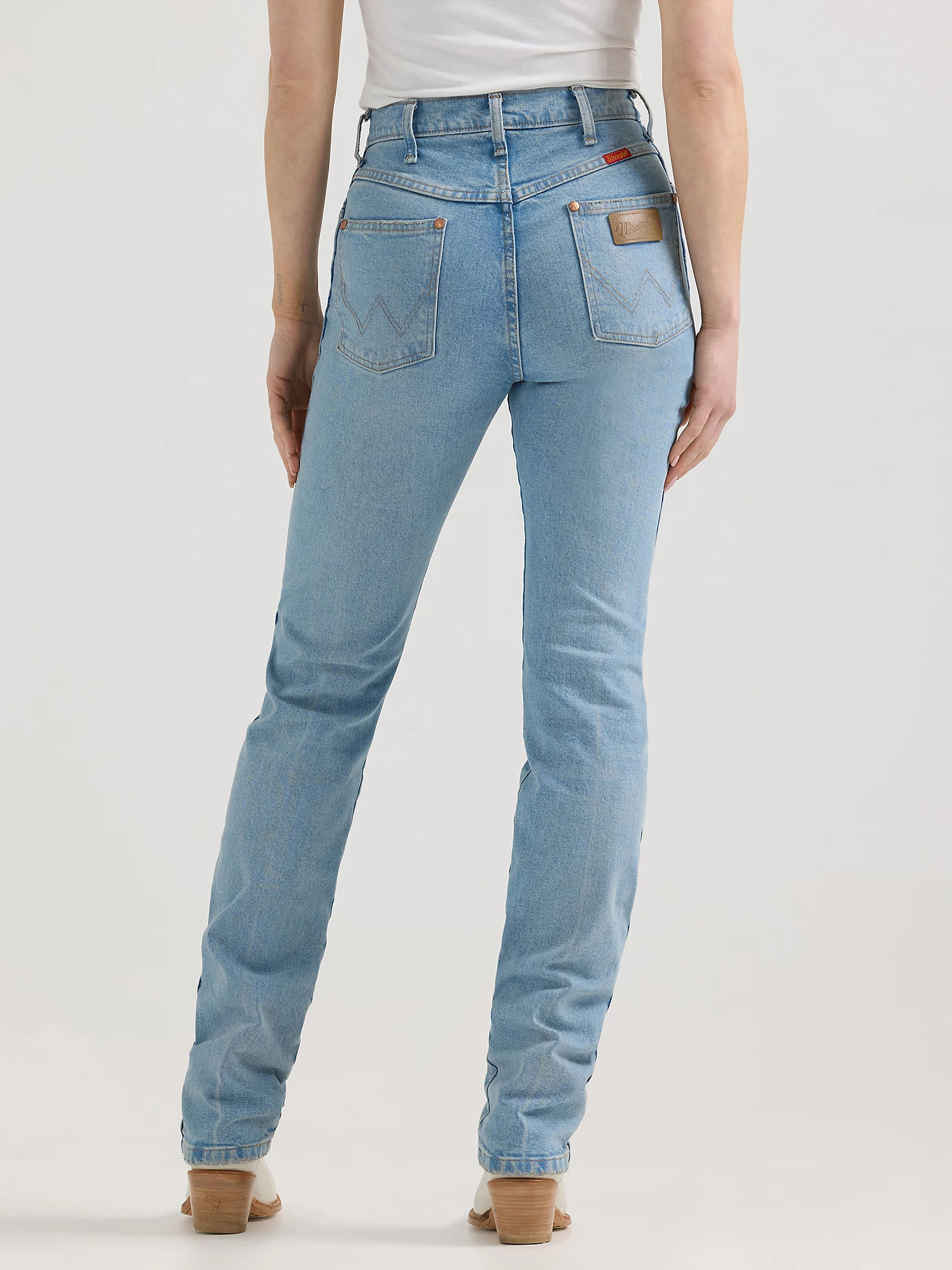 The backside of light wash blue wrangler straight cut jeans.