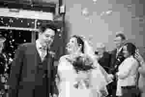 Bride and groom leaving their ceremony showered in confetti