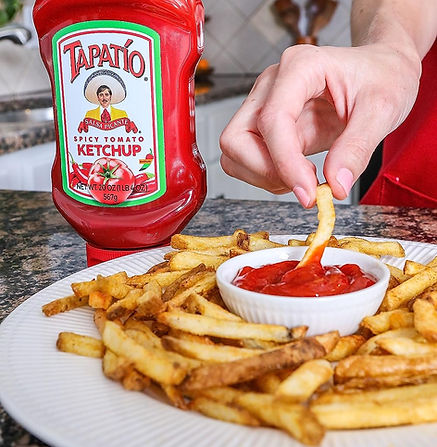 Tempting Tapatio Ketchup accompanies a bowl of crispy french fries, a delightful taste combination