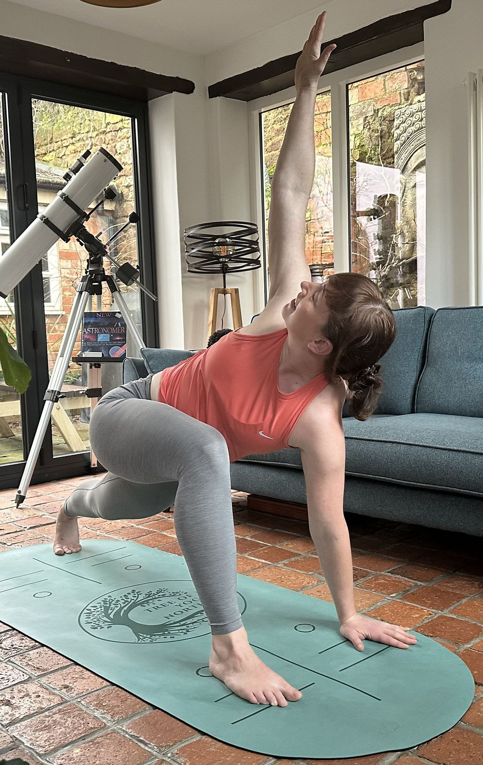 Practicing a twisted lunge, focusing on grounding the back heel and distributing weight evenly, to enhance stability and strength.