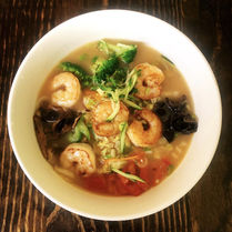 Bowl of shrimp soup with vegetables and mushrooms
