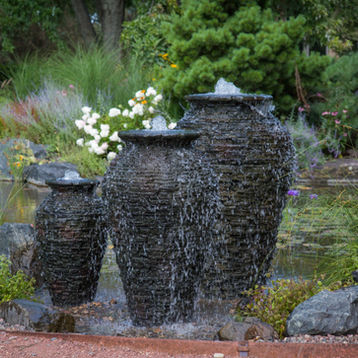 Fountainscape trio comprised of three different sized stacked slate urn fountains