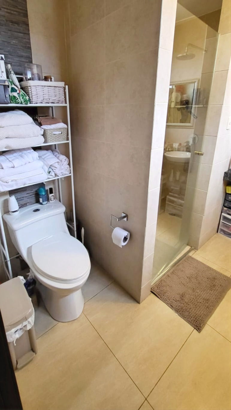 Un baño con inodoro y la puerta de ducha