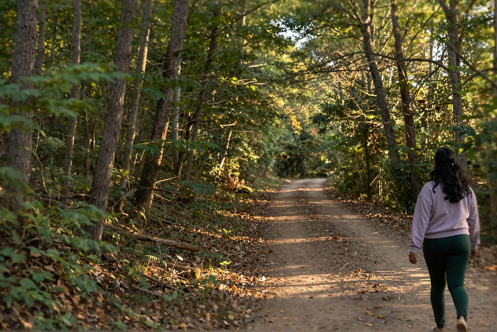 Woman walking on a nature trail, representing the SheCamps approach to calm, clarity, and nervous system regulation.