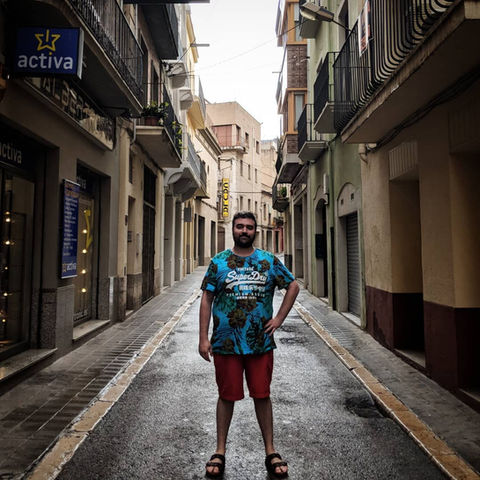 man in 30s standing in European alleyway