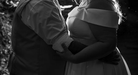 black and white image of a bride and groom with a bright outline created by light