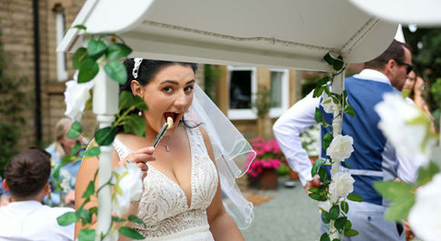Bride smiling at camera about to eat a sweet