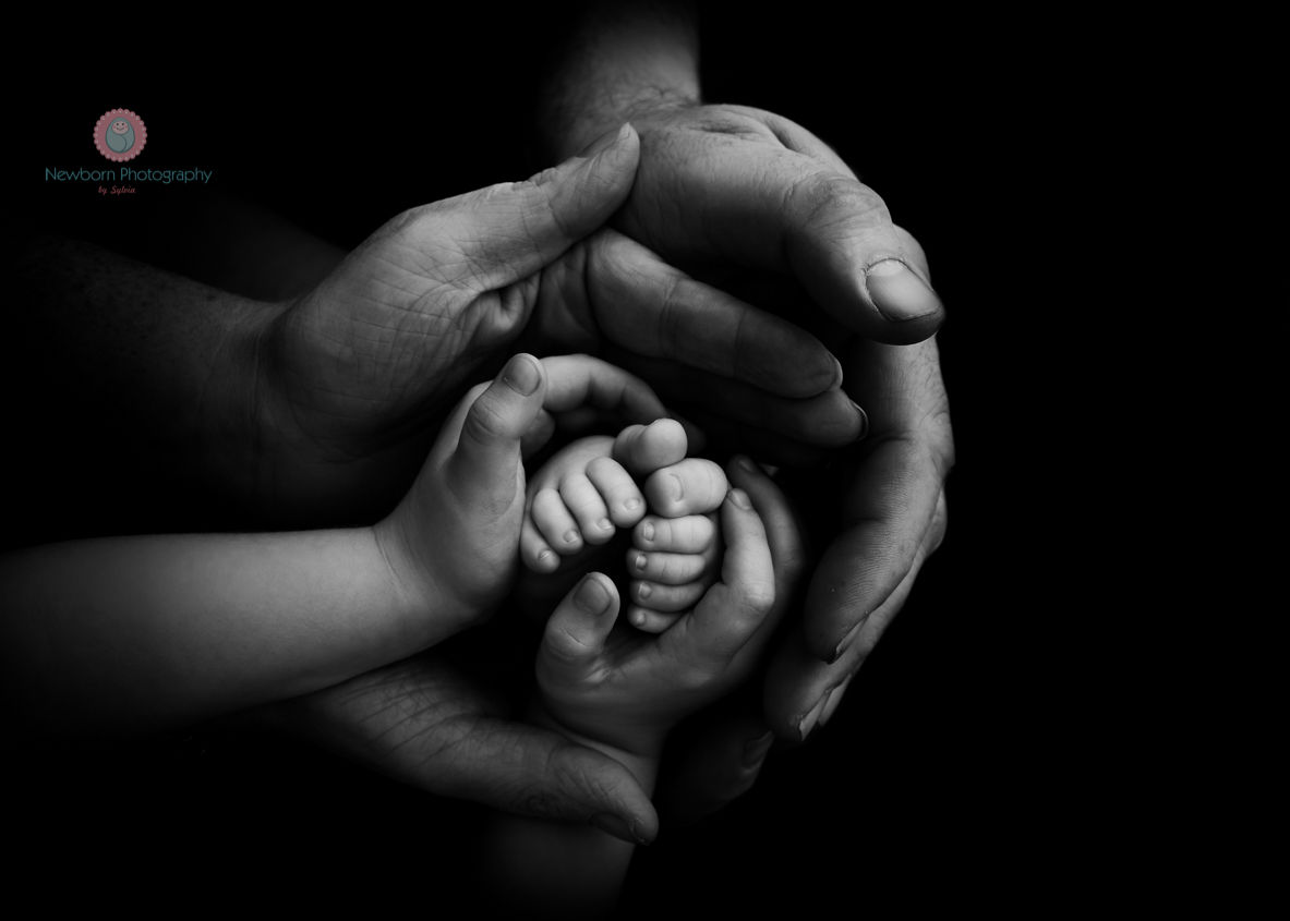 Tiny newborn feet held by parents-Bristol-based newborn photographer