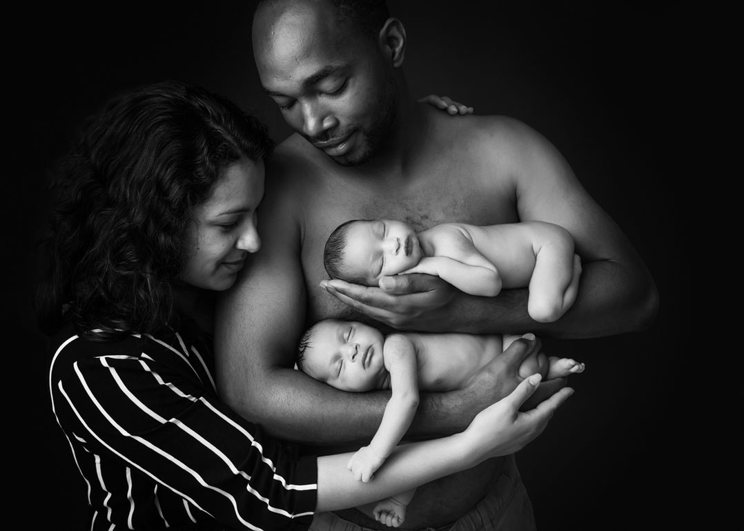 Parents hold their twin newborn girls in arms in Bristol photography studio