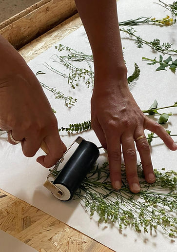 Attendee further flattens flora with a roller in Ink & Paper Italy's Wild Botanical Retreat