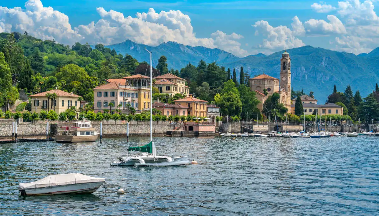 Case e ville e campanile con vista dal Lago. in primo piano barche bianche