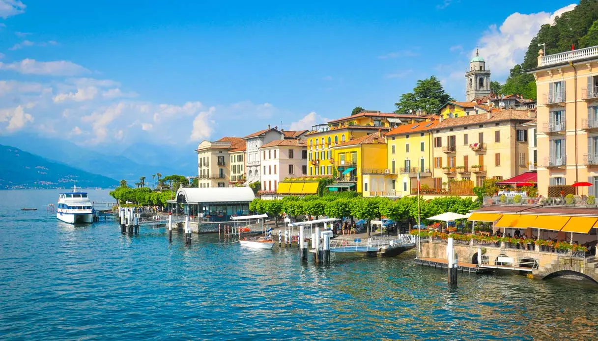 Bellagio dal lago, acqua cristallina e case colorate con imbarcadero