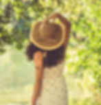 Donna al lago indossa un elegante cappello di paglia a tesa larga BAO HATS, collezione estiva ecosostenibile per boutique e rivenditori premium