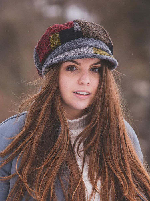 Donna indossa un elegante cappello artigianale durante una passeggiata a cavallo.