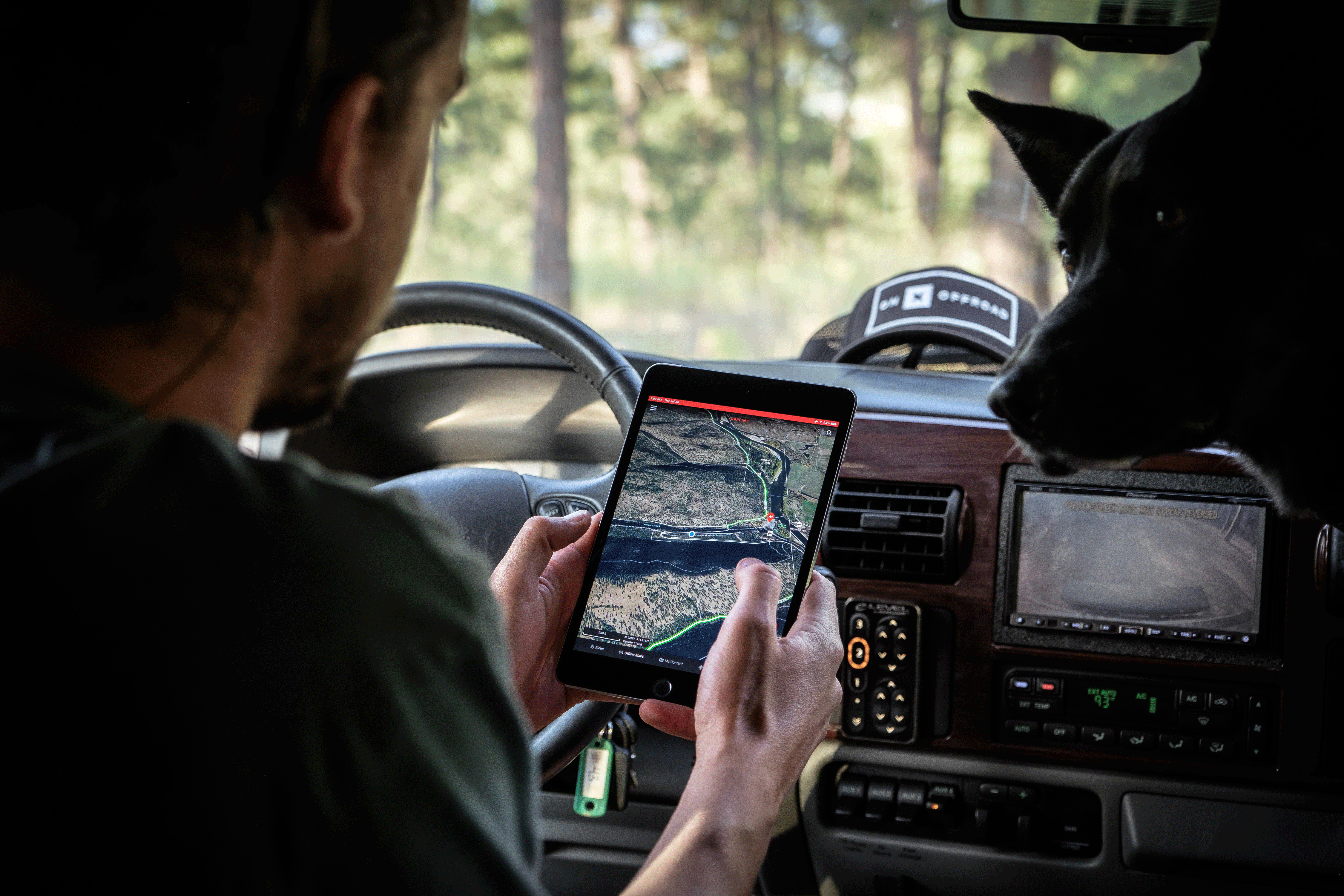 Homme dans une voiture suivant les mouvements d'une personne sur son téléphone