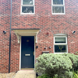 Front of house on quiet residential street with footpath from parking area.