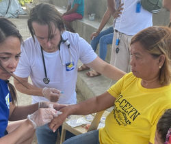 American volunteers Ms. Jennifer Evangelista, RN (left) and Mr. Bailey Frank, RN, treating a patient