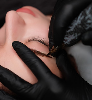 The permanent make-up master applies the permanent on the model's eyebrows. Eyebrow perman