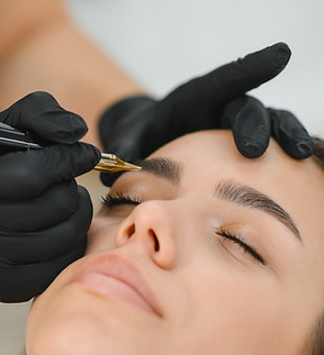 A cosmetologist applies permanent makeup to the eyebrows - eyebrow tattoo. eyebrow perm..j