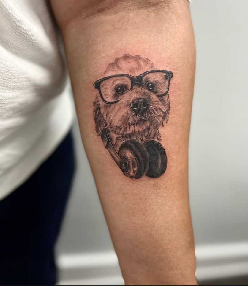 Close-up dog portrait tattoo showing detailed eyes and fur texture