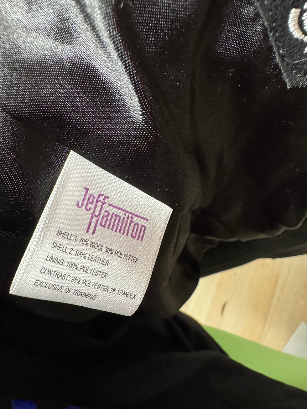 Thumbnail: "Jeff Hamilton" clothing tag displaying material composition inside a dark jacket.