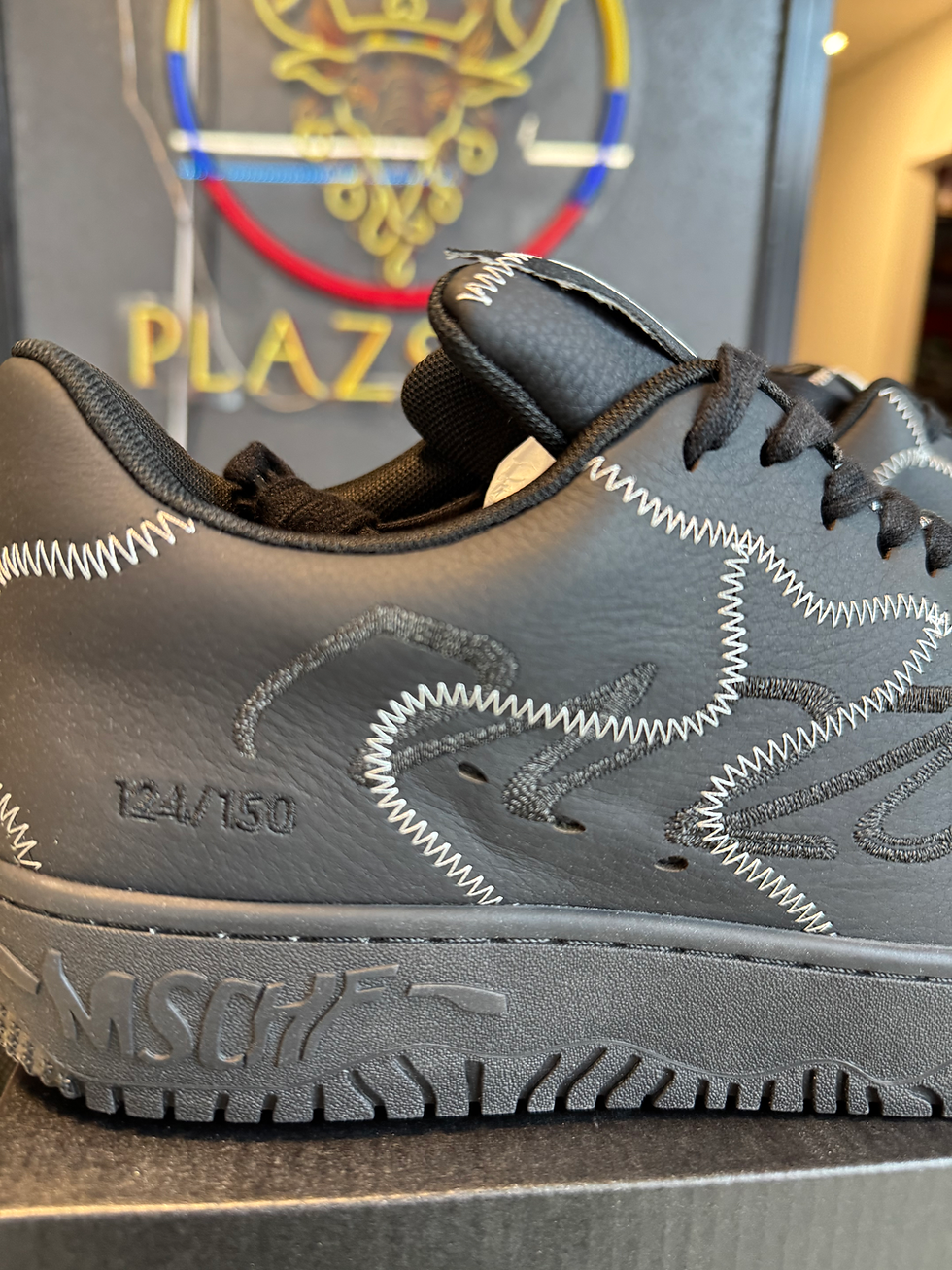 Thumbnail: Black MSCHF sneaker, numbered 124/150, with 'PLAZA' sign in background.