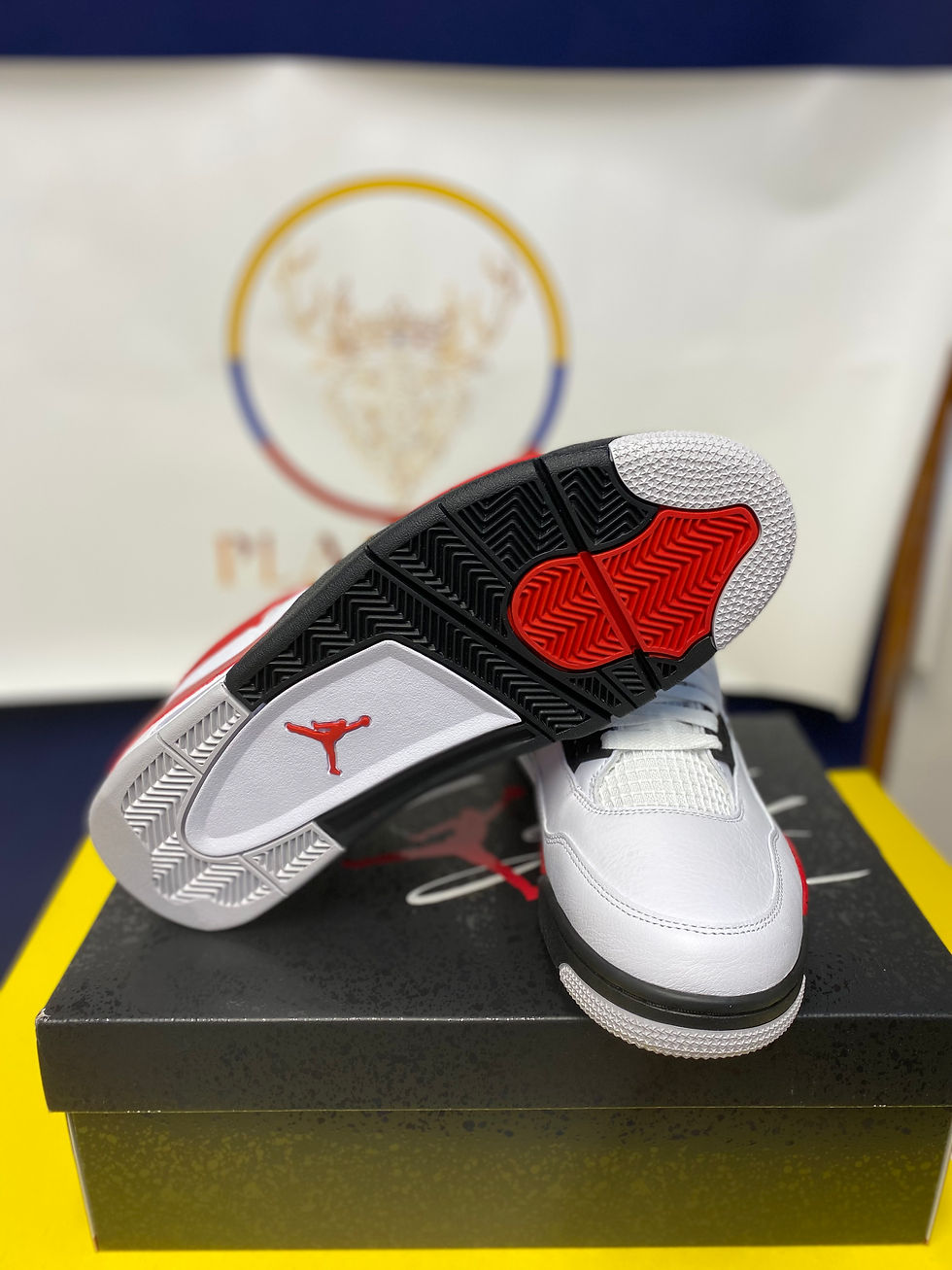 Thumbnail: White and red Air Jordan 4 sneaker showing sole with Jumpman.