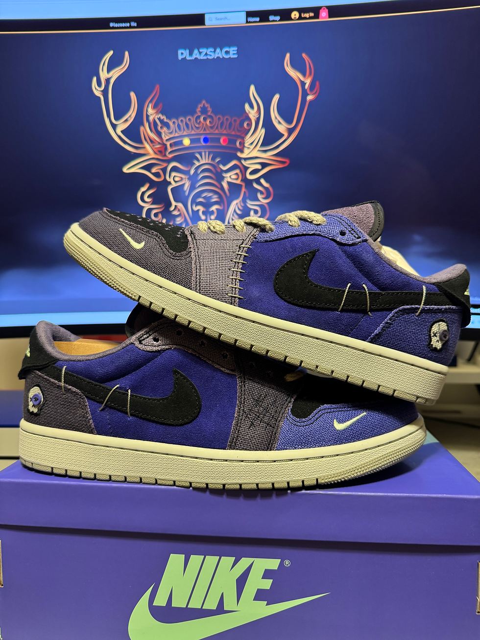 Pair of purple suede Jordan 1 Low sneakers, black swoosh, NIKE box.