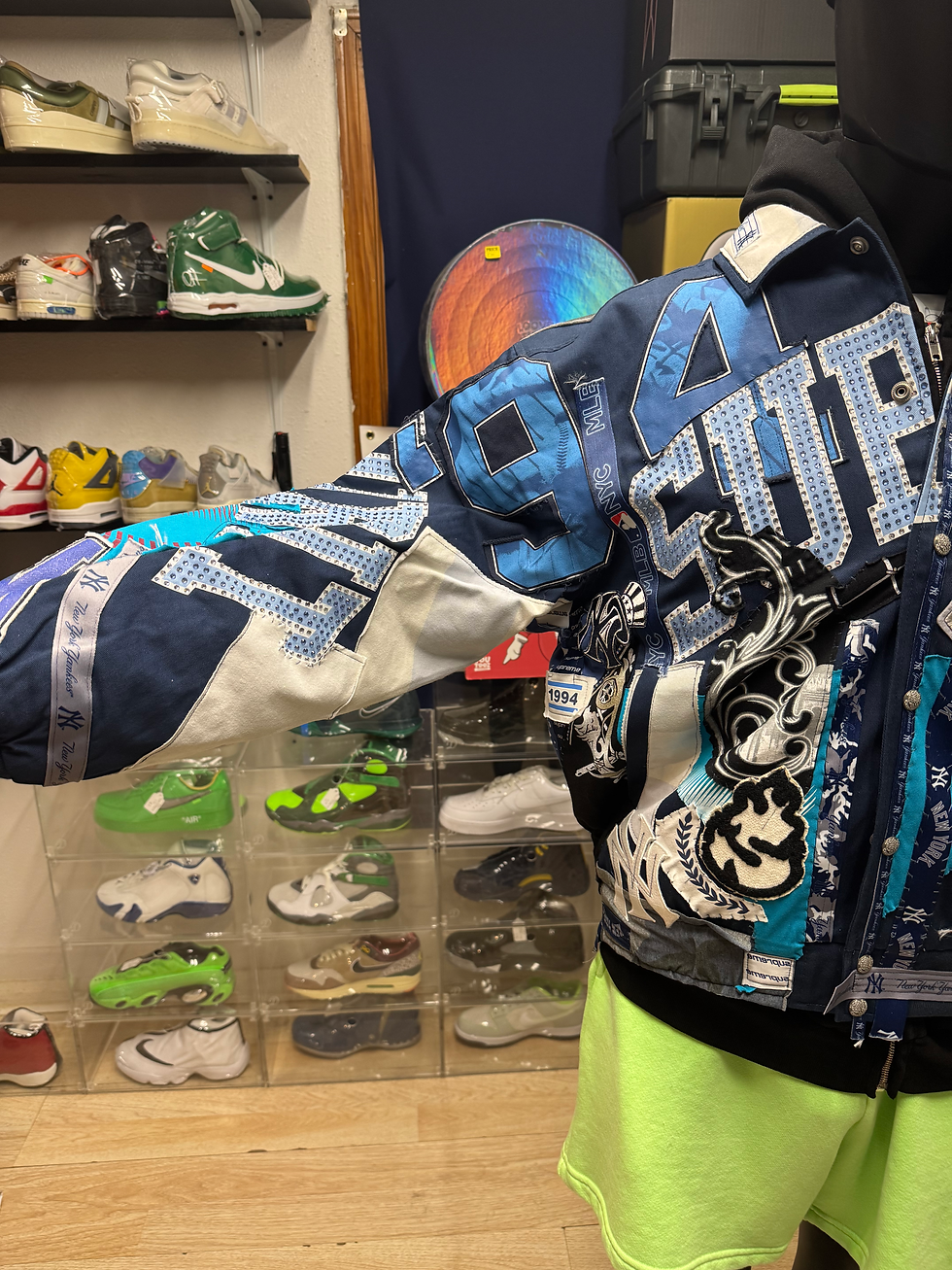 Person wearing blue A-TEAM jacket, numerous sneakers displayed in background.