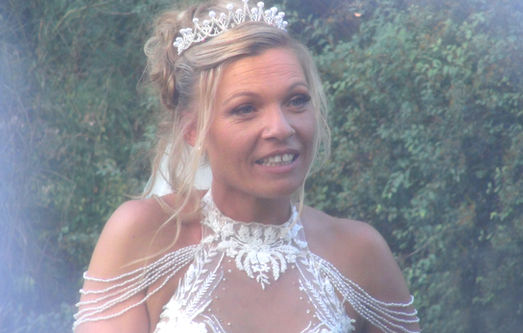 Blonde mariée souriante, portant une couronne et une robe, FILM DE MARIAGE, en extérieur.
