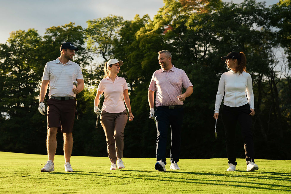 groupe de 4 joueurs de golf qui marche sur le terrain avec leurs bâtons à la main
