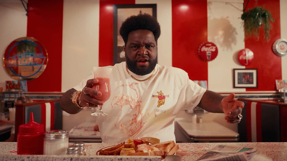 homme dans un casse-croût avec un smoothie rose dans la main et une assiette déjeuner devant lui