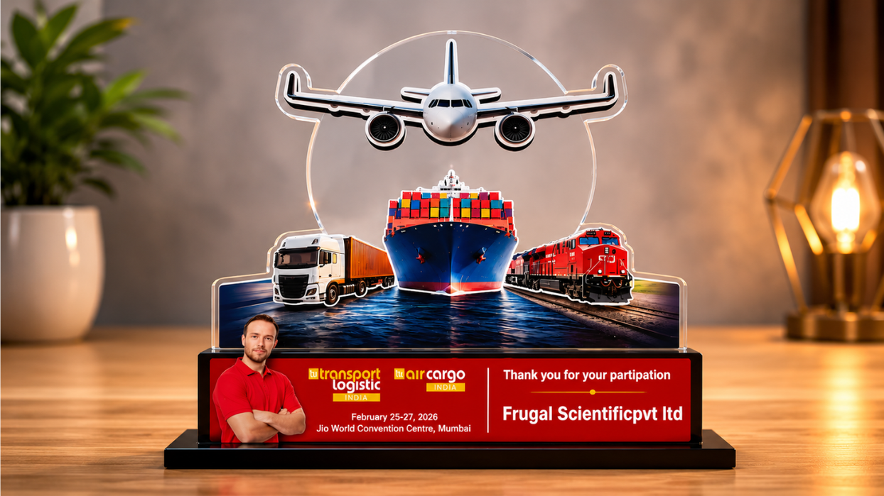 A customized acrylic trophy featuring air, sea, rail, and road transportation elements presented to Frugal Scientific Pvt Ltd for participation in Transport Logistic India and Air Cargo India 2026 at Jio World Convention Centre, Mumbai.