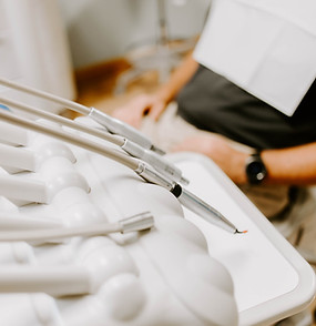 Close up shot of dental equipment with patient in the background.