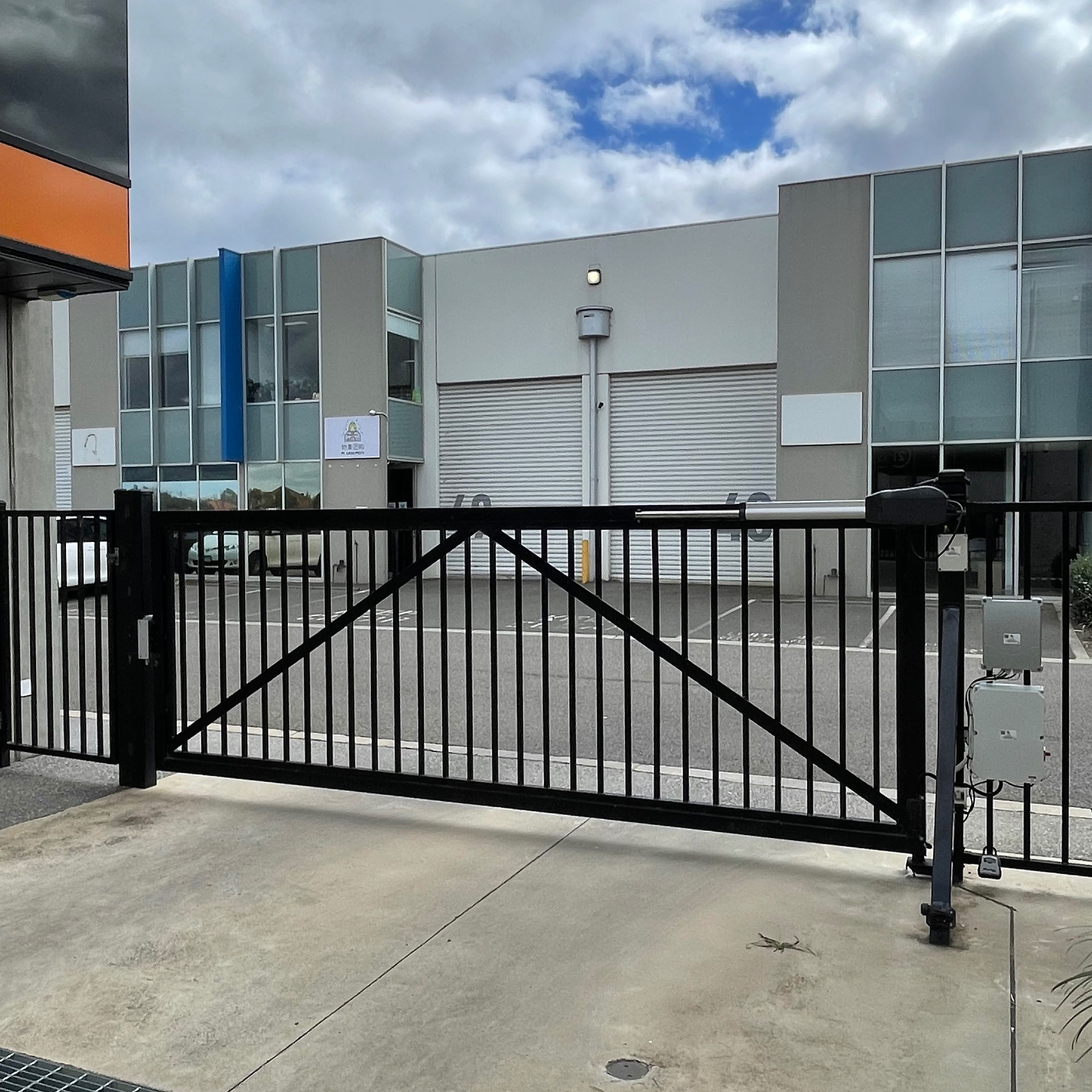 Swing gate opener and magnetic lock installed on a large commercial gate
