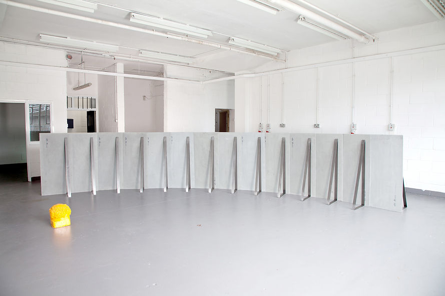 Simona Brinkmann, Ungrammatical Anatomies II, grey Marmox insulation board, cement, fibreglass, steel, graphite. Barrier sculpture, installation, curve obstruction, crowd barrier, post-minimalism, contemporary art.