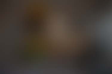 A construction worker wearing safety gear and a hard hat looks over architectural plans on a table. A laptop and a coffee cup sit nearby. The image features an overlaid logo reading “BuildOpsHQ” with text that says “Where Roofing Projects Get Stuck.”