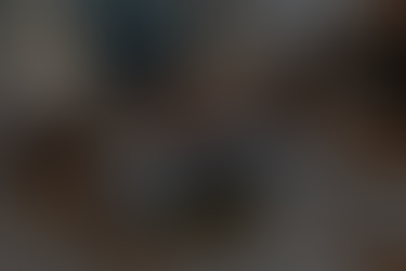 Two people sign an insurance form at a wooden table. A laptop displays graphs, and a model house is nearby. "BUILD OPS HQ" logo visible.