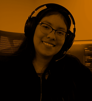 A woman with a headset and glasses is smiling.