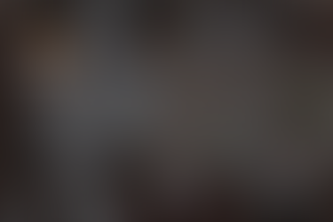 People collaborate over blueprints and maps on a wooden table. Notebooks, pens, a tablet, coffee cups, and the "Build Ops HQ" logo are visible.