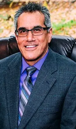 male therapist of hispanic descent wearing purple shirt and tie