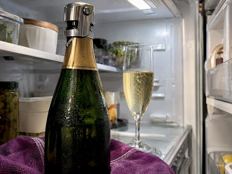 Stopped Champagne bottle chilled beside a flute