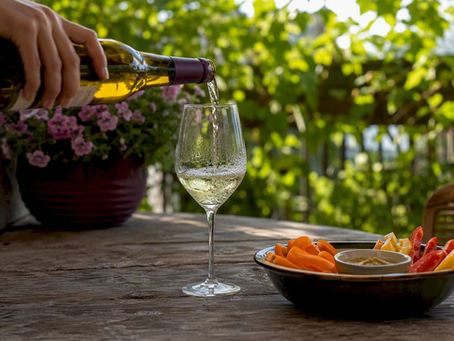 Pouring white wine near chili peppers