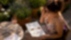 Woman reading beginner wine book at kitchen table