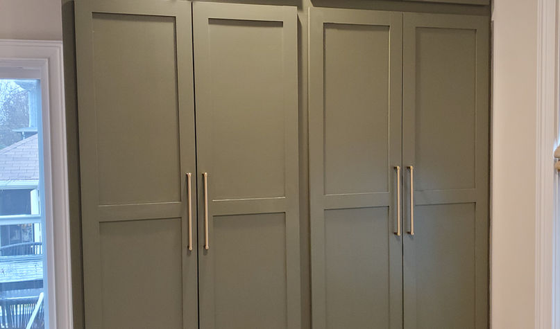 Green custom built-in cabinets with brass handles