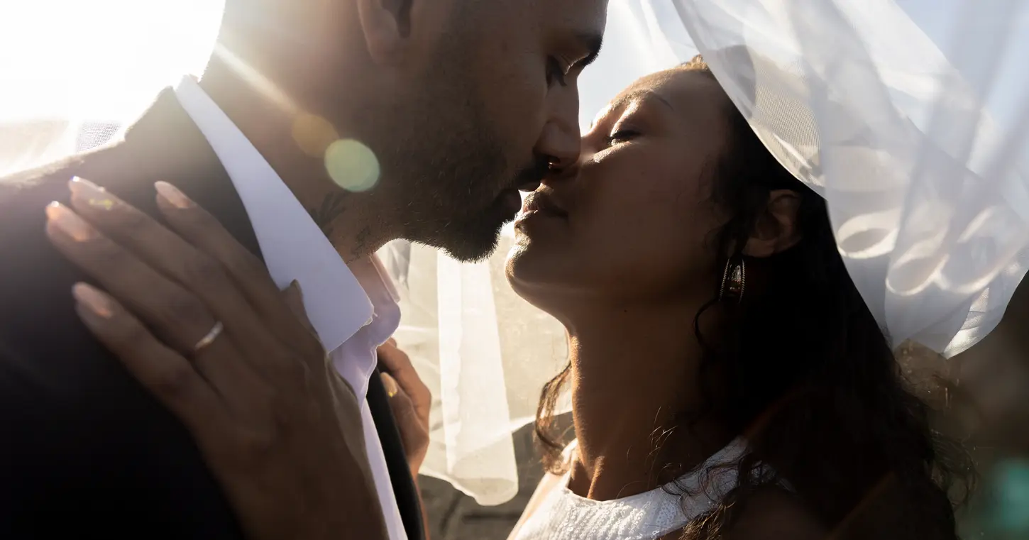 un couple de mariés s'embrassant au coucher de soleil sur l'île de La Réunion pendant une séance photo