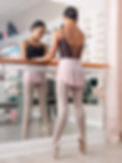 Ballerina is on pointe standing in front of barre at Dance Threadz in Huntington Beach.
