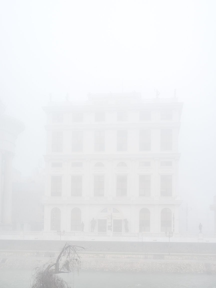 Landscape photograph of a building hidden by smog pollution in Skopje, North Macedonia