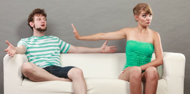 Image d'une femme se disputant avec un homme, sur un canapé