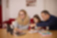 parents with a child at a computer